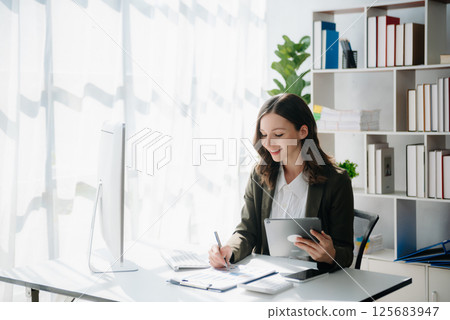 Woman freelancer is working her job on computer tablet and laptop Doing accounting analysis report real estate investment data, Financial at office 125683947
