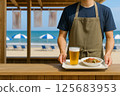 Staff serving food and drinks at the beach house 125683953