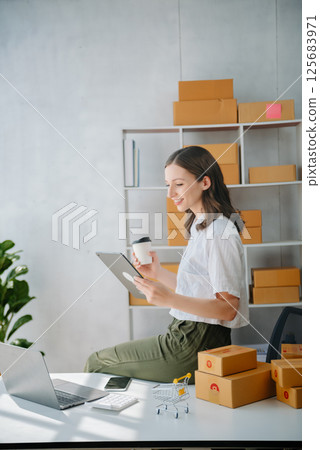 Young women selling clothes on video streaming.Startup small business SME, using smartphone or tablet taking receive and checking. Fashion blogger concept 125683971