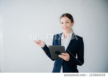 Smiling caucasian young businesswoman bank employee worker manager boss ceo looking at camera, using tablet, laptop and notepad online isolated background 125684203