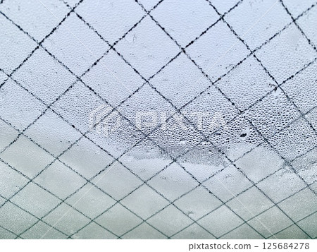 Stock Photo: Image of snow and water droplets on a window 125684278