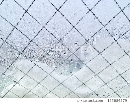 Stock Photo: Image of snow and water droplets on a window 125684279