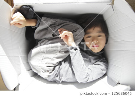 一個男孩在紙箱裡休息 125686045