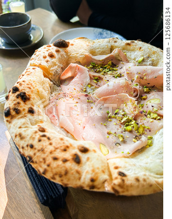Traditional pizza cooked in oven and served in restaurant with melted cheese, meat and pistachio. Alternative taste. Traditional pizza cooked in oven and served in restaurant with melted cheese, meat and pistachio. Alternative taste. 125686134