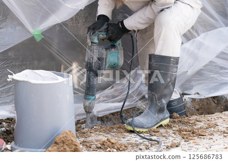 Civil engineering worker breaking concrete with electric hammer (junk hammer) 125686783