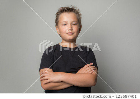 Happy child portrait. Little kid boy standing with crossed arms on white background Happy child portrait. Little kid boy standing with crossed arms on white background 125687401