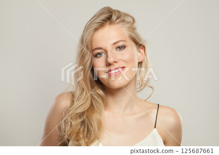 Smiling blond woman with cute smile looking at camera. Beauty young adult person portrait 125687661
