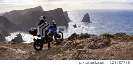 Enduro Motorcycle with Driver Posing on Sea Cliff , Madeira island 125687728