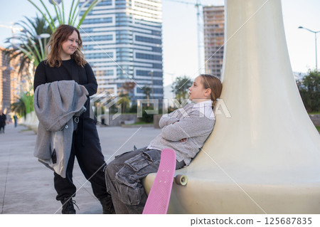 Daughter and mother chatting outdoors. Happy family, lifestyle portrait 125687835