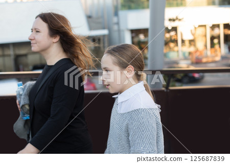 Cute daughter and mother having fun outdoors. Family together. 125687839