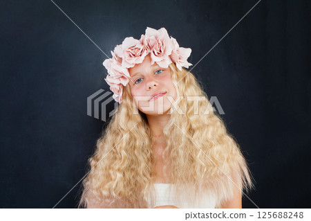 Adorable blond child girl with fashion flower decor on black background portrait Adorable blond child girl with fashion flower decor on black background portrait 125688248