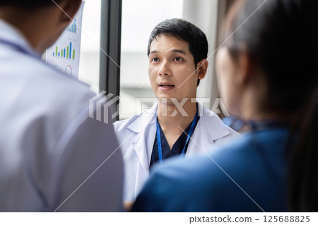 Doctor presenting findings to colleagues in a professional setting 125688825