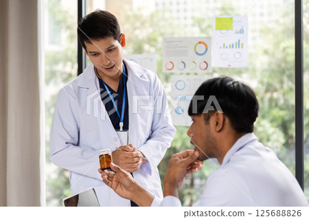 Doctor discussing prescription medication with a colleague 125688826