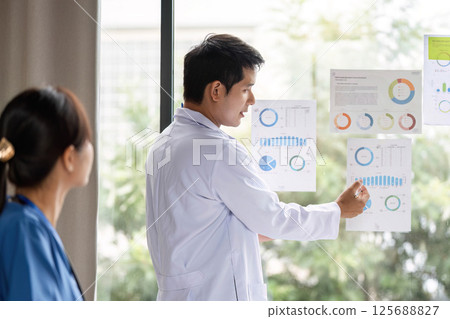 Doctor presenting analysis data to a colleague during a meeting 125688827