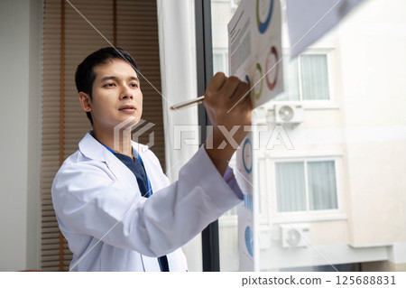 Doctor presenting data insights on charts in a hospital meeting Doctor presenting data insights on charts in a hospital meeting 125688831