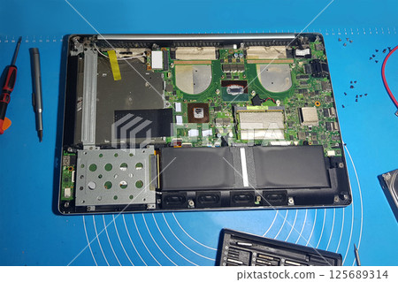 Brocken motherboad on the table waiting for being repared 125689314