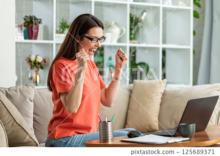 Excited woman celebrating success at laptop Excited woman celebrating success at laptop 125689371