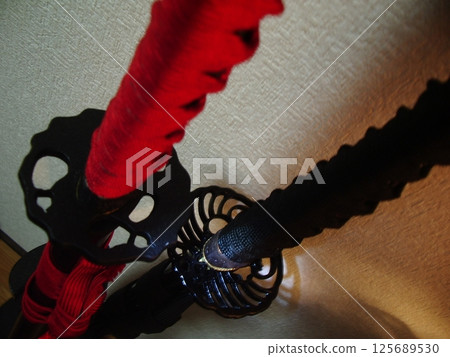 The tsuba and hilt of two Japanese swords The tsuba and hilt of two Japanese swords 125689530