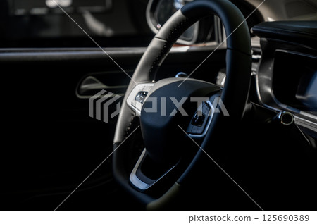 A close-up of a modern car's steering wheel with control buttons A close-up of a modern car's steering wheel with control buttons 125690389
