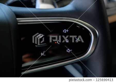 A close-up of a modern car's steering wheel with control buttons A close-up of a modern car's steering wheel with control buttons 125690413
