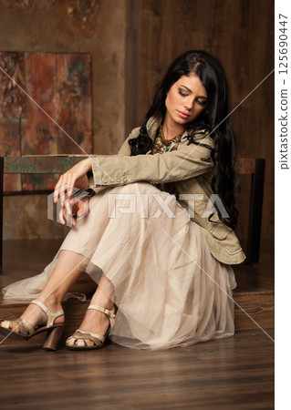 Beautiful woman with long hair and make-up sitting in vintage luxurious interior Beautiful woman with long hair and make-up sitting in vintage luxurious interior 125690447