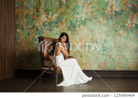 Gorgeous woman with long hair and make-up sitting in vintage luxurious interior 125690464