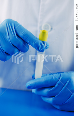 laboratory worker holding a test tube with semen 125690796