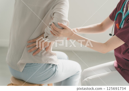 Patient experiencing pain behind the right lower back Patient experiencing pain behind the right lower back 125691734
