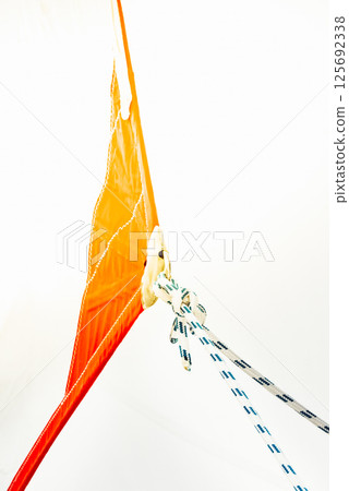 Sailing boat ropes tied to an orange sail, abstract composition, background 125692338