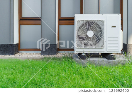 Outdoor air conditioner unit on building wall Outdoor air conditioner unit on building wall 125692400