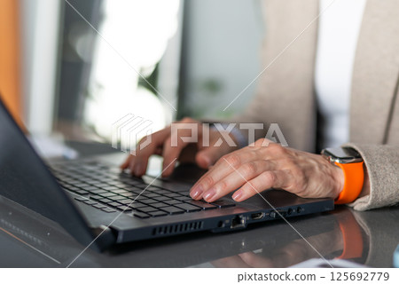 Female hands on a laptop keyboard works 125692779