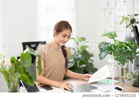 ESG sustainability practices with young woman working in eco-friendly office ESG sustainability practices with young woman working in eco-friendly office 125693258