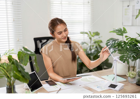 ESG sustainability efforts with woman analyzing data in green office ESG sustainability efforts with woman analyzing data in green office 125693261