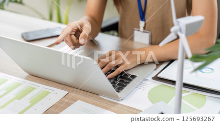 ESG sustainability consultant pointing at laptop screen in office ESG sustainability consultant pointing at laptop screen in office 125693267