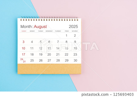 August 2025 desk calendar on blue and pink background, with copy  space. 125693403