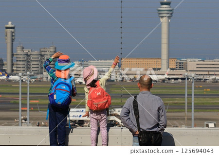 Parents and children waving to a departing plane at the observation deck at Haneda Airport Parents and children waving to a departing plane at the observation deck at Haneda Airport 125694043