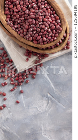 Bowls full of dried azuki beans on gray top view. Vegetarian protein source, East Asian legumes Bowls full of dried azuki beans on gray top view. Vegetarian protein source, East Asian legumes 125694199