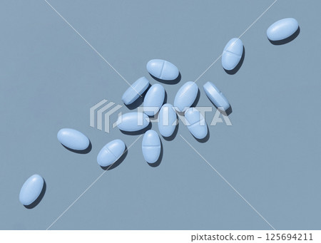 Blue medical pills on blue top view, hard light. Pharmaceutical products for healthcare Blue medical pills on blue top view, hard light. Pharmaceutical products for healthcare 125694211