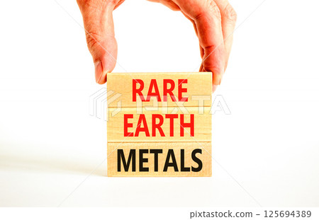 Rare earth metals symbol. Concept words Rare earth metals on beautiful wooden block. Businessman's hand. Beautiful white background. Business and rare earth metals concept. Copy space. 125694389