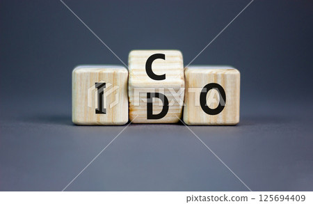 Initial coin or DEX offering symbol. Concept words abbreviation ICO or IDO on wooden block. Beautiful grey table grey background. Business Initial coin or DEX offering concept. Copy space. 125694409