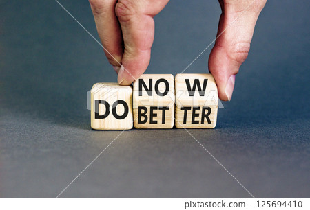 Do better and now symbol. Concept words Do better Do now on wooden block. Beautiful grey table grey background. Businessman hand. Business do better and now concept. Copy space. 125694410