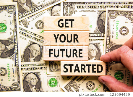 Get your future started symbol. Concept words Get your future started on beautiful wooden blocks. Beautiful background from dollar bills. Business get your future started concept. Copy space. Get your future started symbol. Concept words Get your future started on beautiful wooden blocks. Beautiful background from dollar bills. Business get your future started concept. Copy space. 125694439