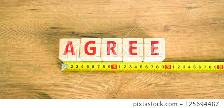 Agree symbol. Concept word Agree on beautiful wooden blocks. Beautiful wooden table wooden background. Beautiful yellow ruler. Business agree concept. Copy space. 125694487