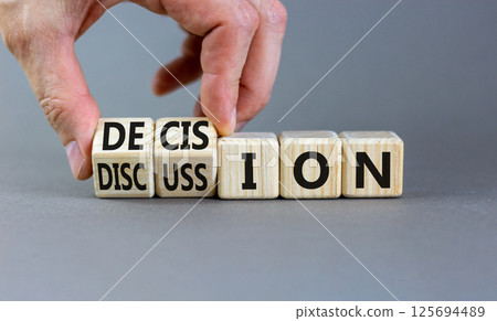 Discussion and decision symbol. Concept word Discussion and Decision on wooden cubes. Businessman hand. Beautiful grey table grey background. Business discussion and decision concept. Copy space. Discussion and decision symbol. Concept word Discussion and Decision on wooden cubes. Businessman hand. Beautiful grey table grey background. Business discussion and decision concept. Copy space. 125694489