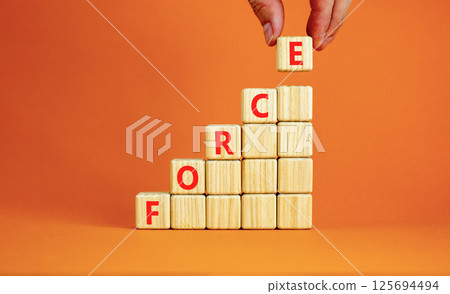 Force symbol. Concept word Force on beautiful wooden blocks. Beautiful orange table orange background. Businessman hand. Business lifestyle force concept. Copy space. Force symbol. Concept word Force on beautiful wooden blocks. Beautiful orange table orange background. Businessman hand. Business lifestyle force concept. Copy space. 125694494
