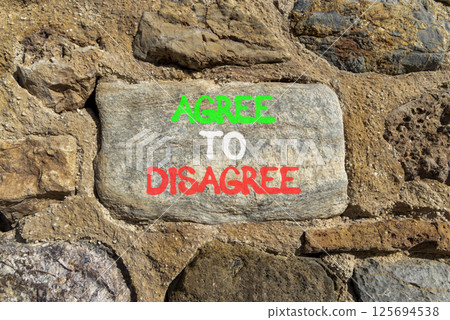 Agree to disagree symbol. Concept words Agree to disagree on beautiful grey stone wall. Beautiful stone wall background. Business and agree to disagree concept. Copy space. Agree to disagree symbol. Concept words Agree to disagree on beautiful grey stone wall. Beautiful stone wall background. Business and agree to disagree concept. Copy space. 125694538