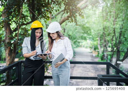 Confident team of female architect working together at terrace. They discussing about new startup project. Architect discuss with engineer about project . Architectural concept. Confident team of female architect working together at terrace. They discussing about new startup project. Architect discuss with engineer about project . Architectural concept. 125695400