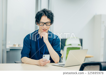 看智能手機並且認為的商人 125695978