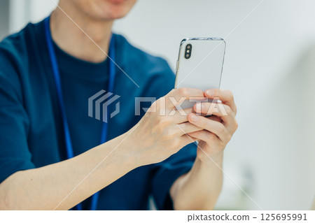 Hand of a man manipulating a smartphone Hand of a man manipulating a smartphone 125695991