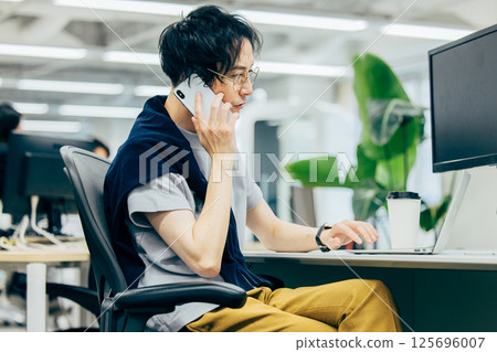 A young businessman calling in the office A young businessman calling in the office 125696007